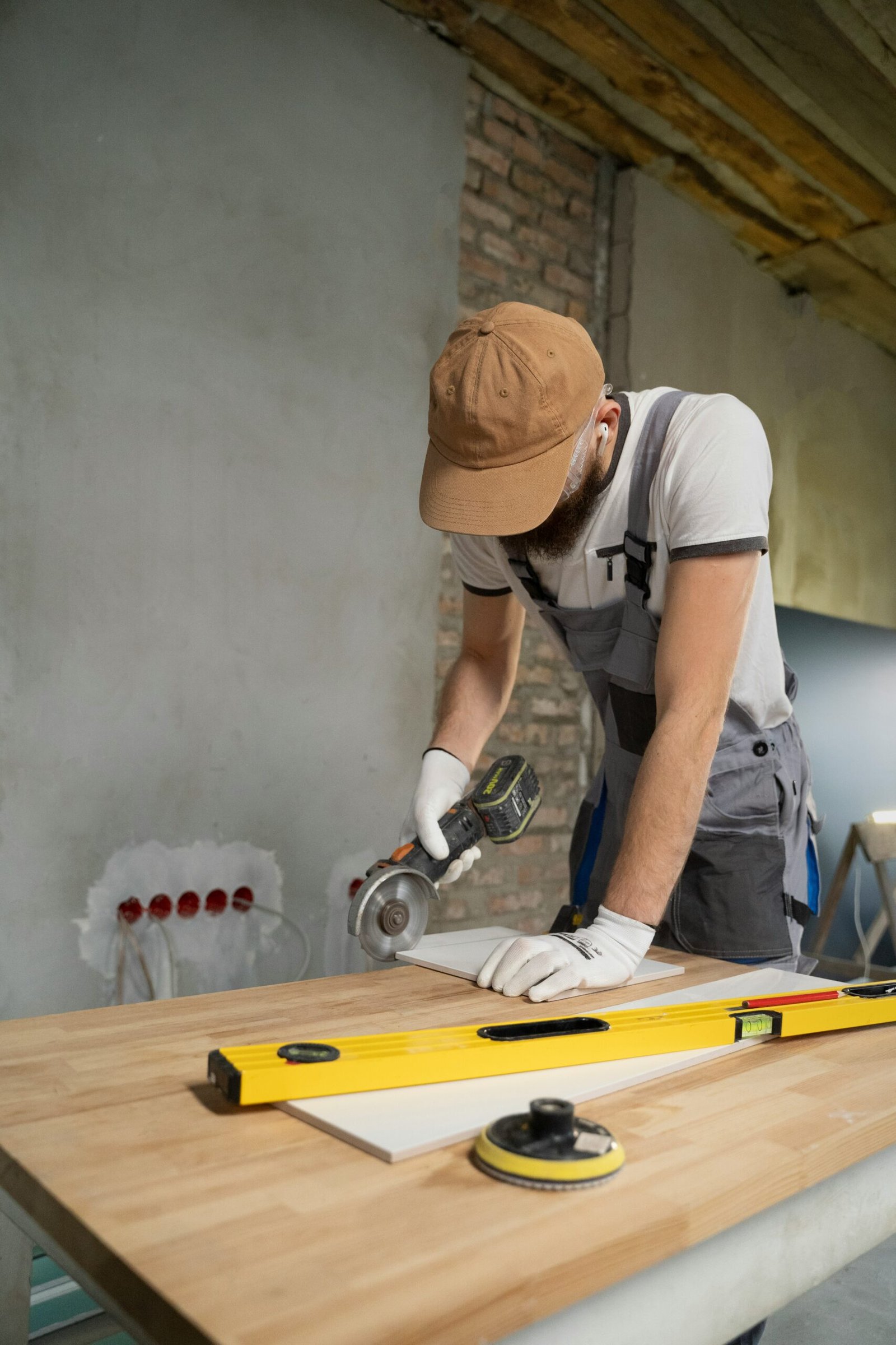 A man sanding a wooden table with a sander