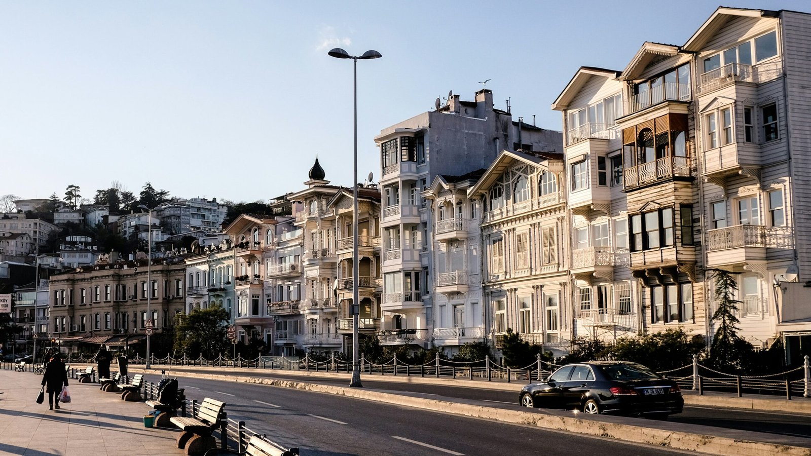 black car parked beside white concrete building during daytime